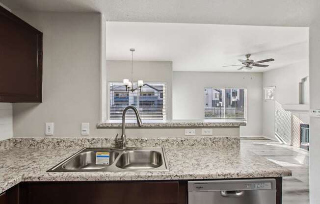 A kitchen with a granite countertop and stainless steel appliances.