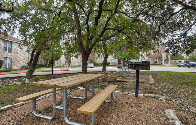 a picnic area with benches and a grill at The Broadwater at Salado Creek, Texas