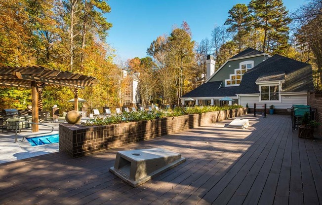 a large deck with a pool and a house in the background