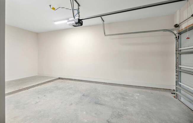 A large empty room with a garage door on the side.