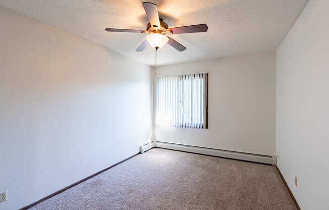 a bedroom of an empty apartment with a ceiling fan.  Eagan, MN Glen Pond Apartments