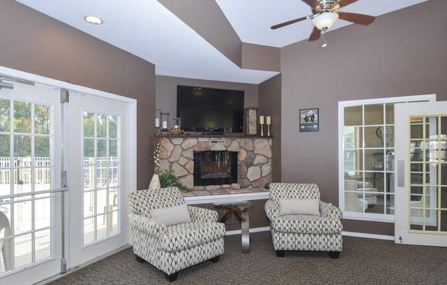 a living room with a fireplace and two chairs