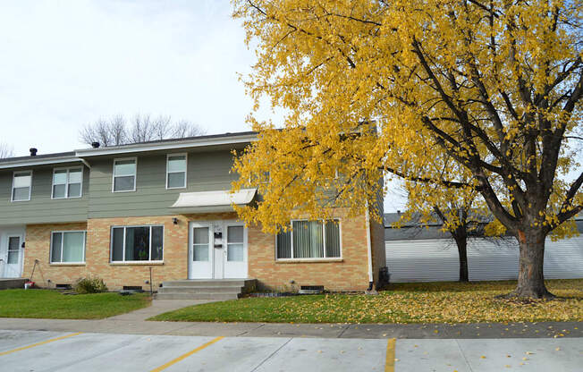 the front of a house with a tree with yellow leaves. Fargo, ND Sheyenne Terrace