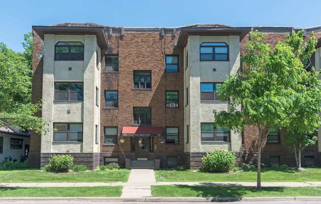 an apartment building with a tree in front of it