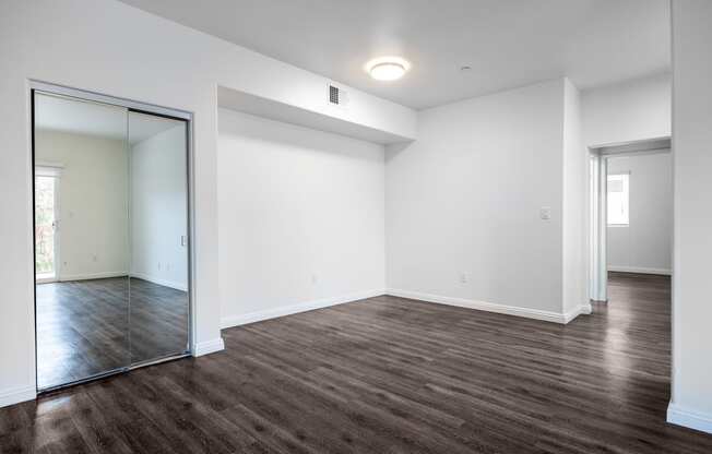 a bedroom with white walls and a large mirror