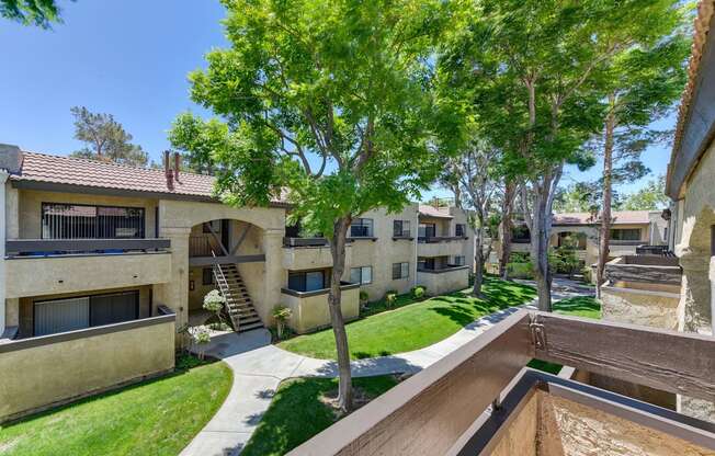 A view of a courtyard with a tree and apartment buildings.