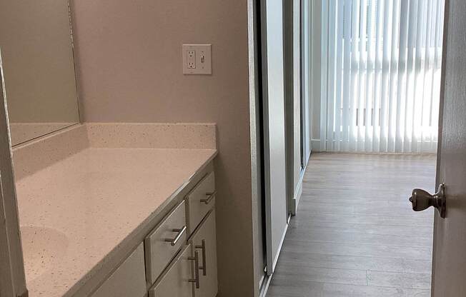 A kitchen with white cabinets and a counter top.