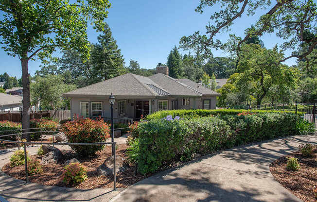 A clubhouse with a grey roof and a fence in front of it at Rocklin Gold Apartments, California, 95677