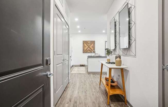 a hallway with a door to a kitchen and a table