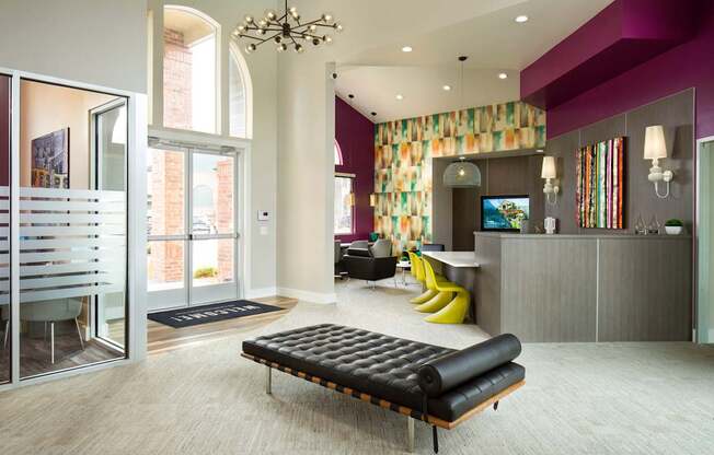 A modern living room with a black bench and a chandelier.