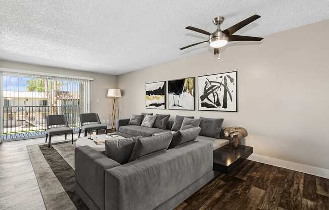 a living room with a large couch and a ceiling fan