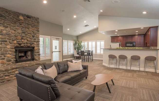 A clubhouse with a stone fireplace and a couch at Zinfandel Village Apartments, California, 95670