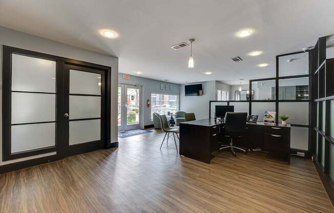 A modern office space with a wooden floor and glass walls.