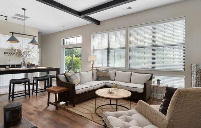 a living room with couches and chairs and a kitchen with windows at Hayden Lofts, Dublin, OH, 43016