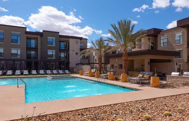 pool area with buildings and trees in the background at escape at arrowhead's apartments in glendale, az