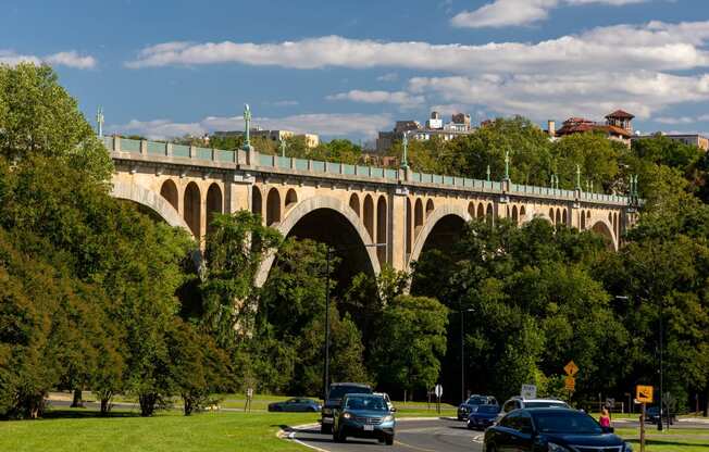 a bridge over a road with cars driving under it