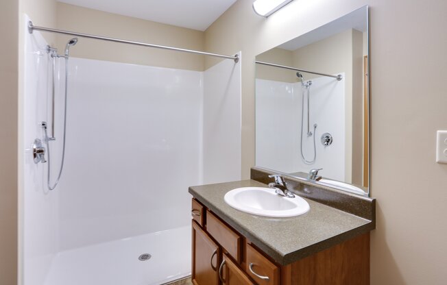 an empty bathroom with a sink and a shower