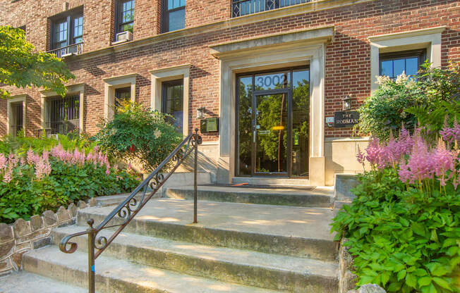 the front of a brick building with stairs and a glass door