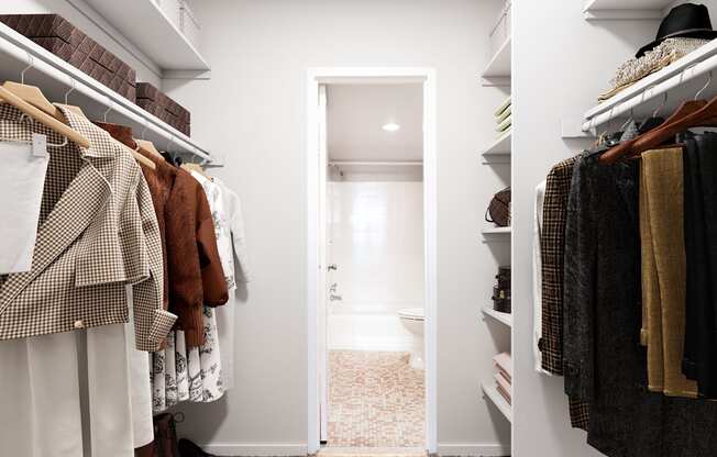 a walk in closet filled with clothes and a door to a bathroom