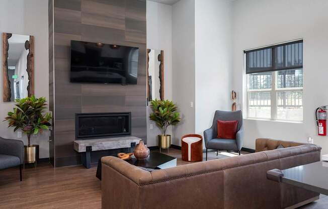 A living room with a brown couch and a fireplace.