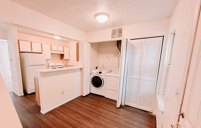 a white kitchen with a washer and dryer in it