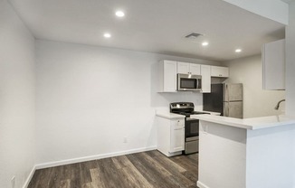 updated kitchen with white cabinets and stainless steel appliances