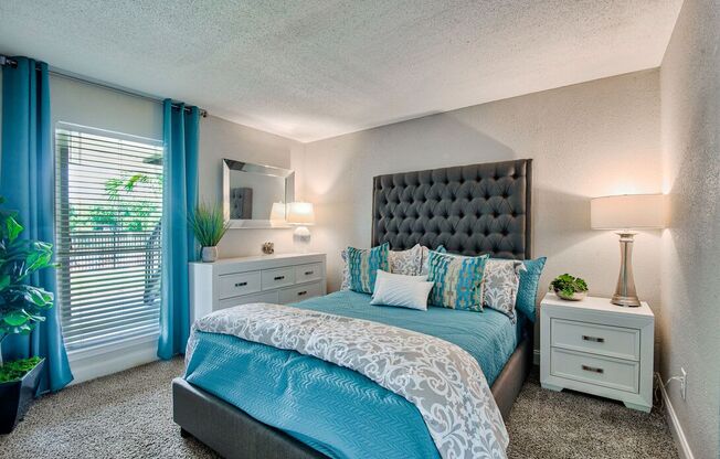 A bedroom with a large bed and a mirror on the wall.