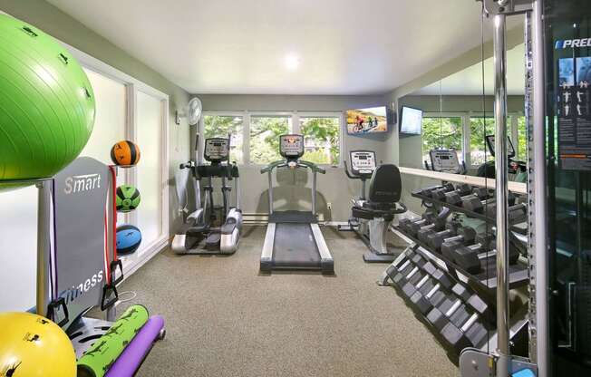 a gym with cardio equipment and a window view of the outdoors