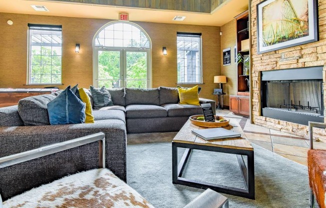 A living room with a grey couch and a fireplace.
