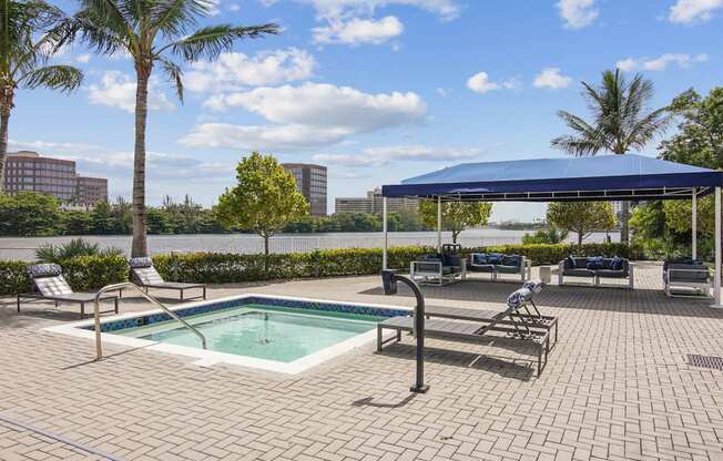A pool area with a blue canopy and a view of the city skyline.