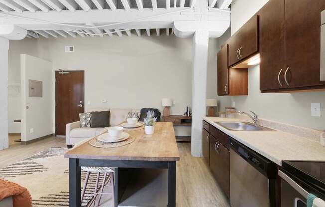A kitchen with a table set for two and a dining area.