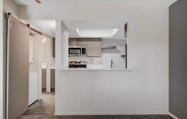 A kitchen with white cabinets and a white countertop.