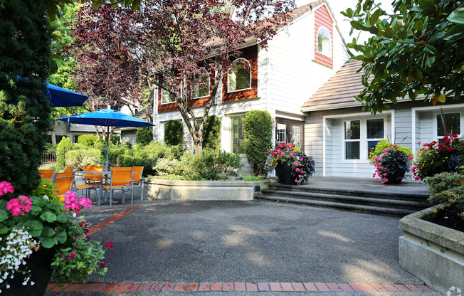 Fulton's Crossing and Landing Apartments  patio and yard of a white house with a patio table and chairs