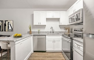 a kitchen with white cabinets and stainless steel appliances