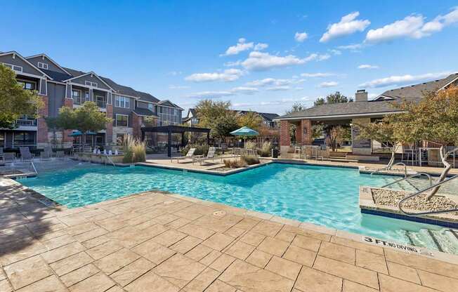 A large outdoor swimming pool surrounded by a tiled patio.