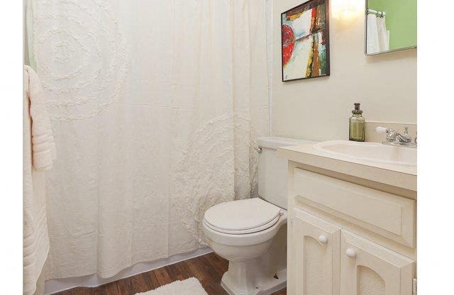 a white bathroom with a shower curtain and a toilet