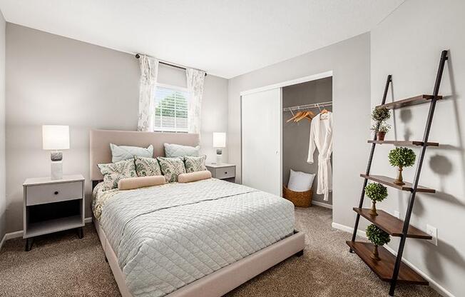 A bedroom with a large bed and a wooden ladder.