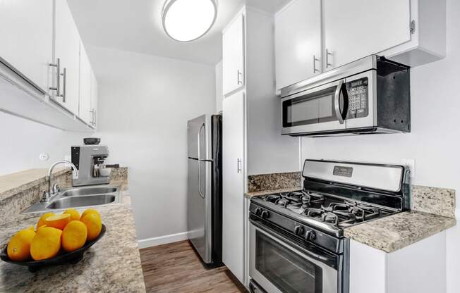 a kitchen with stainless steel appliances and a counter top with oranges