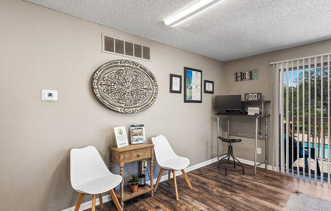 a living room with two chairs and a table and a window