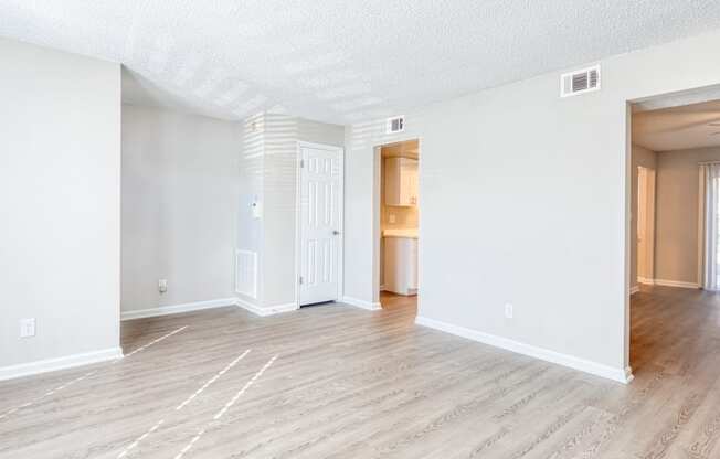 the living room and dining room of an apartment with wood flooring