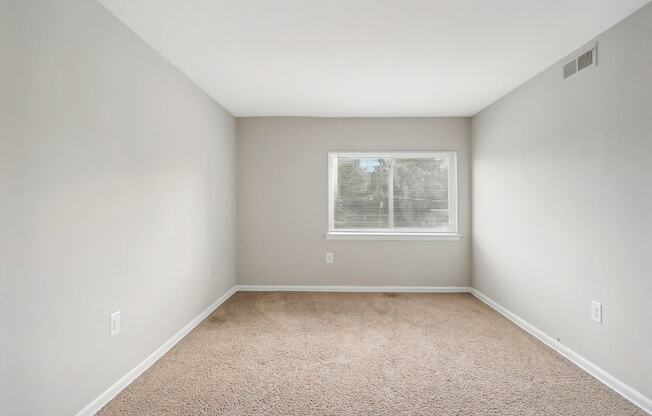 an empty room with carpet and a window