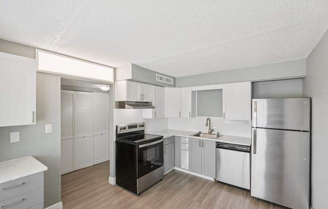 A kitchen with a black stove top oven and a silver refrigerator.