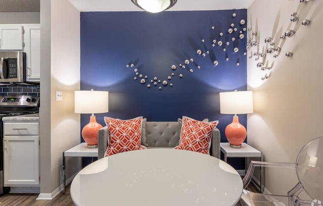 a living room with a blue accent wall and a round table