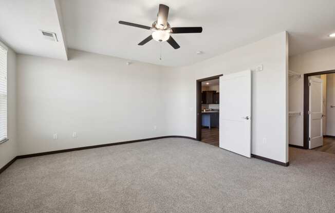 a living room with carpet and a ceiling fan