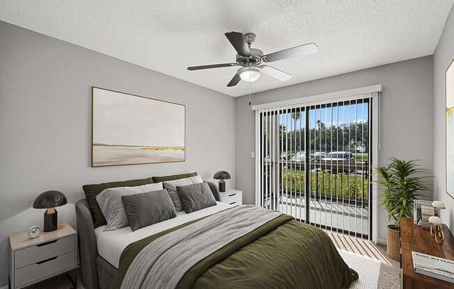 Model Bedroom with Carpet and Patio Accessibility at Fountains Lee Vista Apartments in Orlando, FL.
