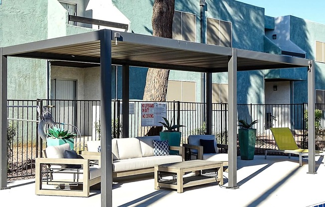 A poolside lounge area with a canopy and seating.