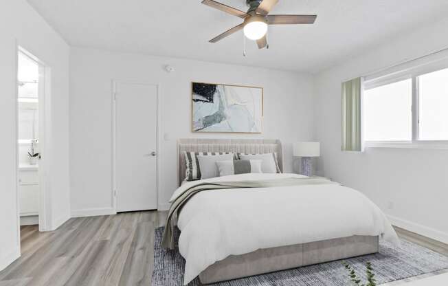 a bedroom with a large bed and a ceiling fan