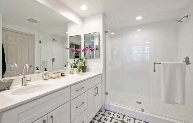 a white bathroom with a shower and a sink