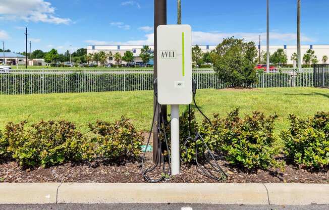a power outlet on the side of a road with a green grassy field in the background