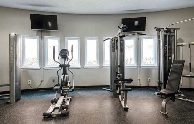 a gym with weights and a row of windows